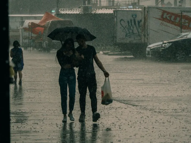 Tânăr cuplu mergând prin ploaie, sub umbrelă - Foto: Pexels/Nikita Korchagin