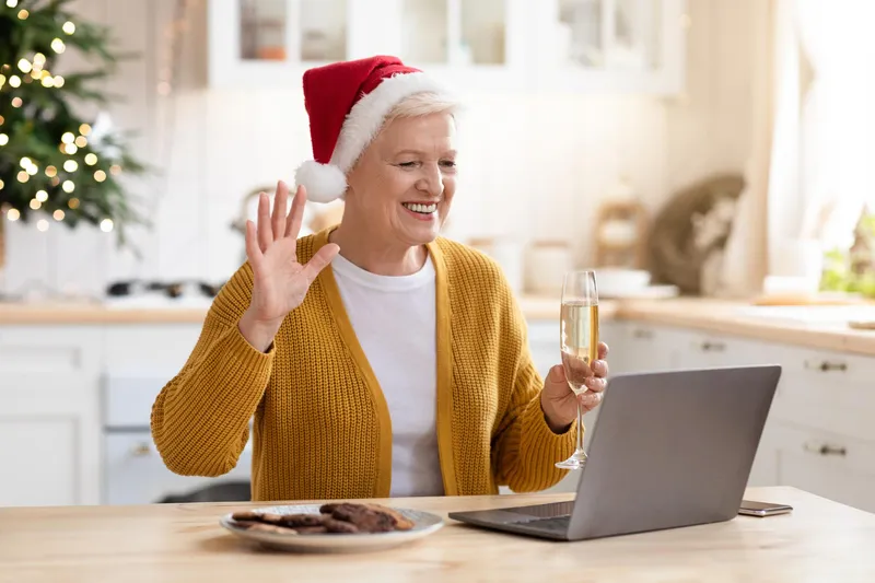 Pensionară care bea un pahar de șampanie și vorbește cu prietenii online - Foto: Freepik (Imagine cu rol ilustrativ)