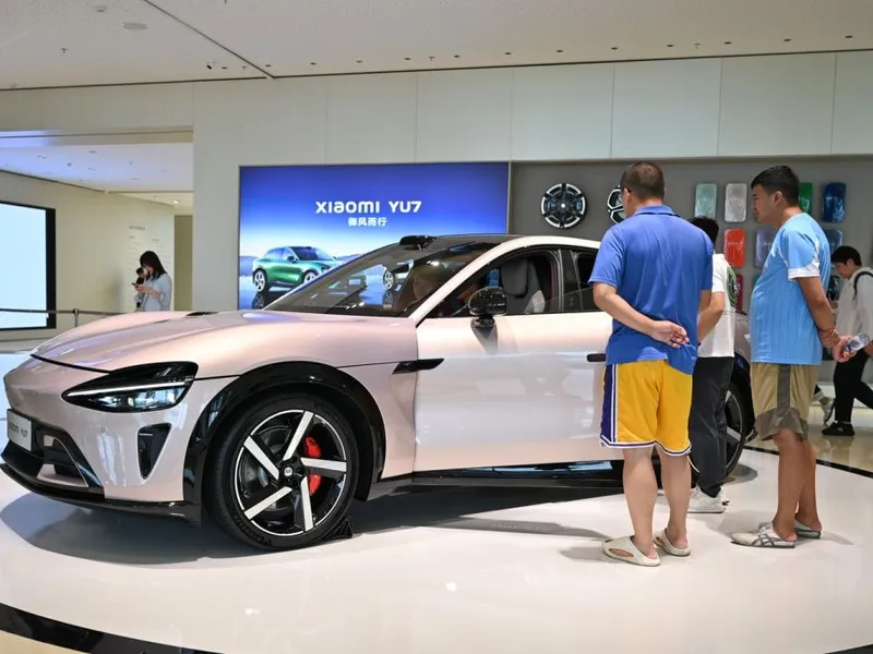 Doi bărbați stau lângă un SUV YU7 al mărcii chineze Xiaomi - Foto: Profimedia Images