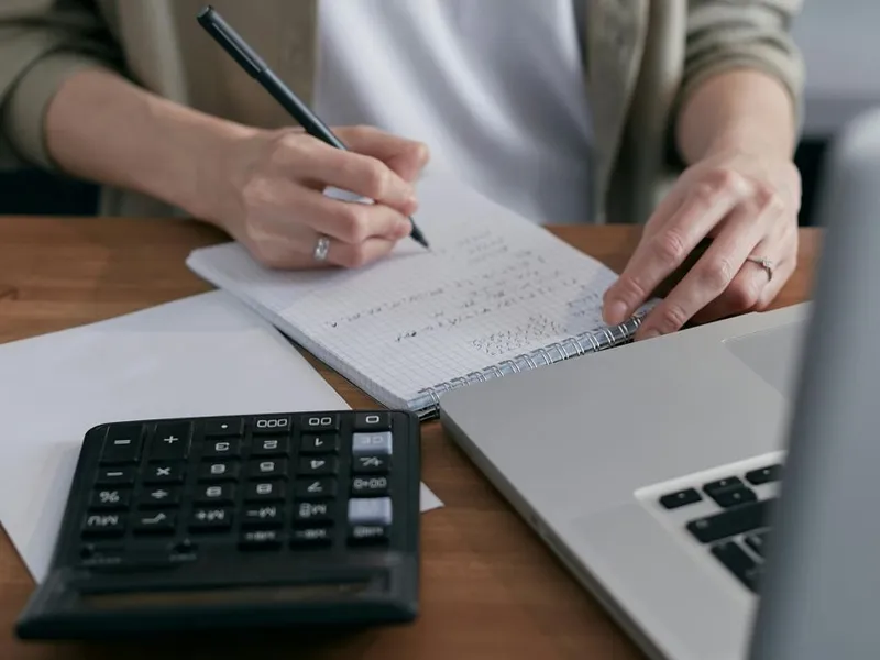 Femeie făcând calcule contabile - Foto: Pexels/Mikhail Nilov