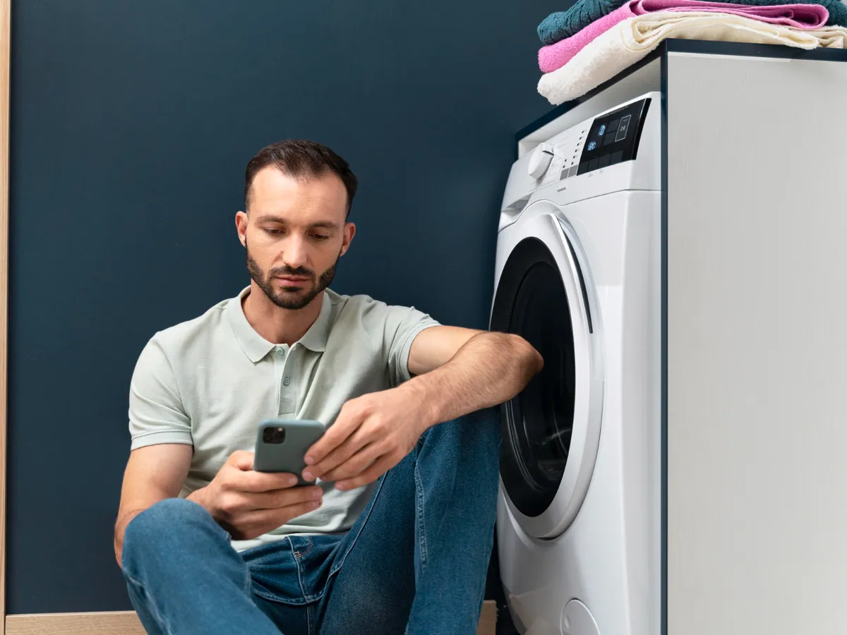Bărbat lângă mașina de spălat - Foto: Freepik (Imagine cu rol ilustrativ)