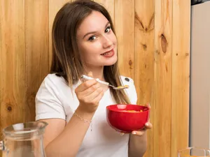 Femeie frumoasă care ține un bol roșu în mână - Foto: Freepik (imagine cu rol ilustrativ)