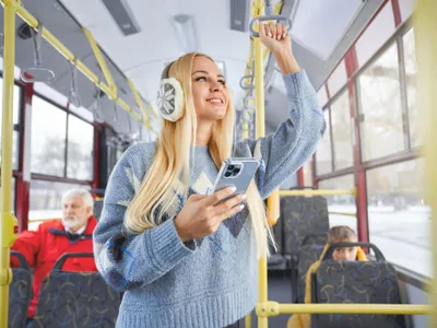 O femeie ascultă muzică la cățti în autobuz - Foto: magnific (rol ilustrativ)