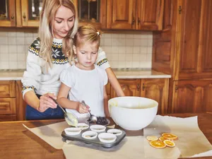 Mamă și fiică pregătesc împreună brioșe cu ouă - Foto: Freepik