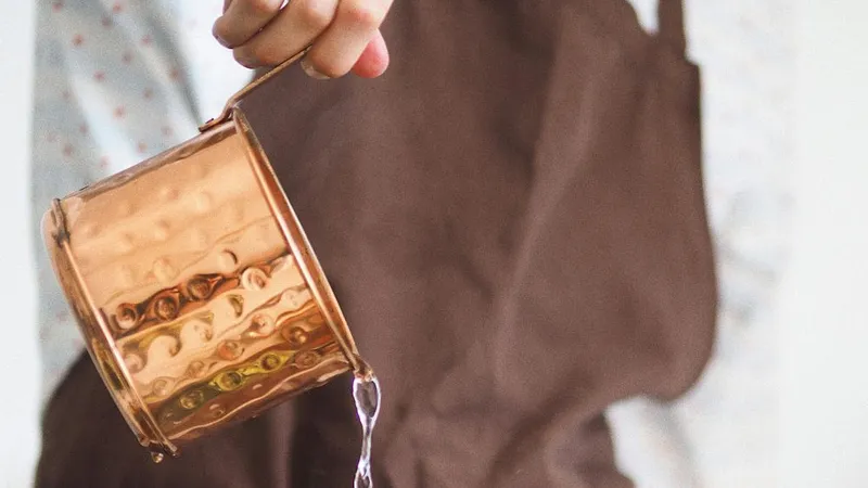 Femeie vărsând apă dintr-un recipient de sticlă - Foto: Pexels/Maria Verkhoturtseva