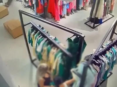 Două femei suprinse ca iau haine dintr-un magazin - Foto: Captură video