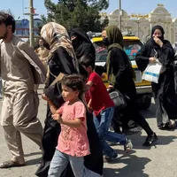 Mamele disperate îşi aruncă copiii peste gardul de la Kabul, implorând soldații să îi salveze/FOTO: indianexpress