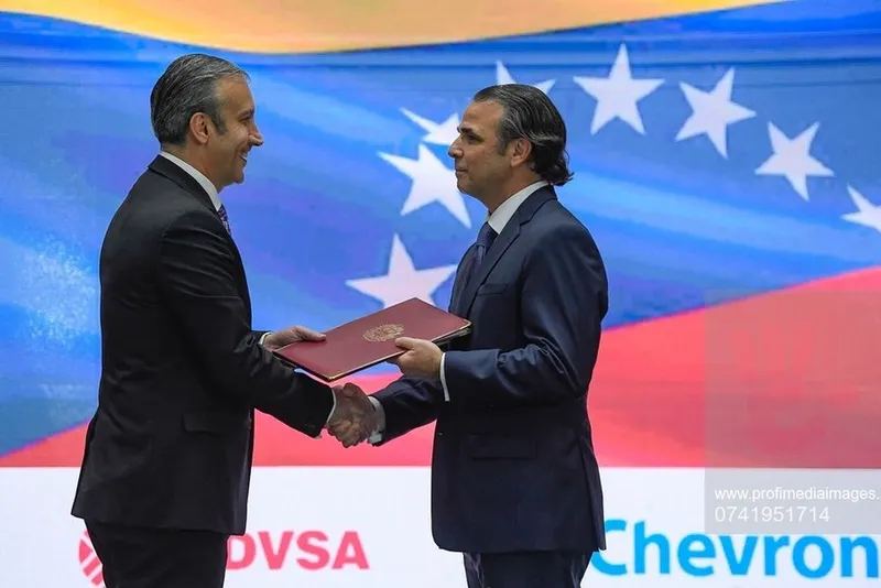 Ministrul petrolului din Venezuela, Tareck El Aissami, (st&acirc;nga), dă m&acirc;na cu președintele Chevron din Venezuela, Javier La Rosa, &icirc;n timpul unei ceremonii de semnare a acordului, la Caracas - Foto: Profimedia Images - Foto: Profimedia Images