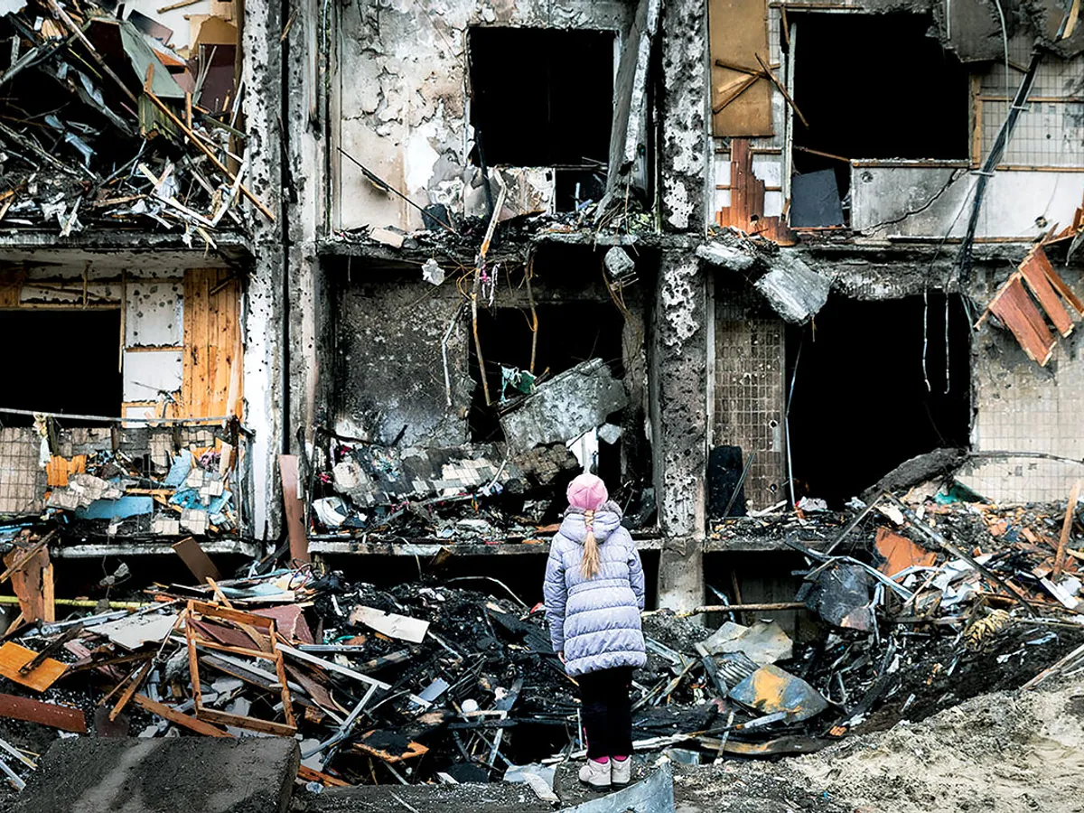 fată examinează pagubele produse la o clădire de apartamente din Kiev