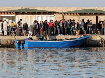 Mai mulți migranți coboară dintr-o barcă în care au călătorit/FOTO: Reuters