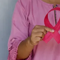 O femeie ține o panglică roz ca simbol al luptei împotriva cancerului de sân/FOTO: unsplash.com