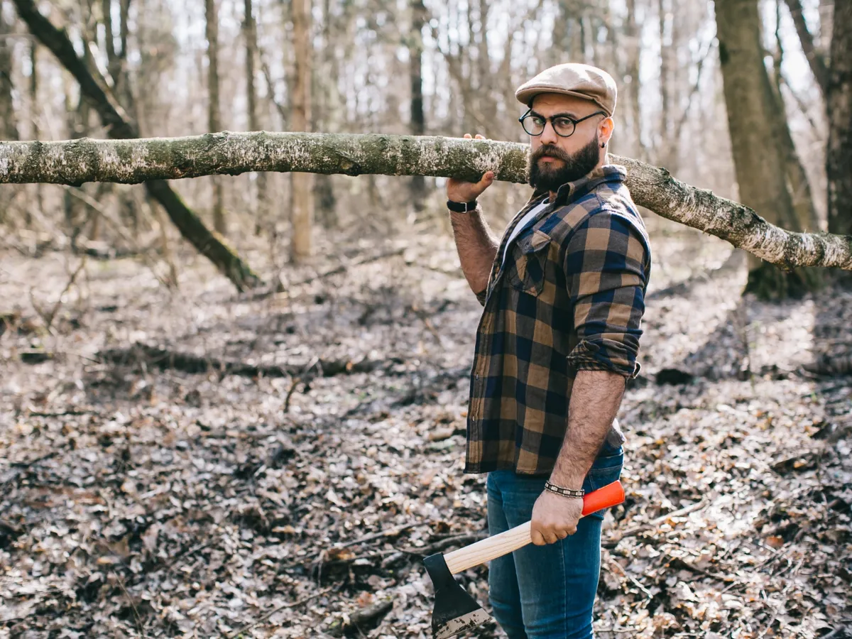 Bărbat care a tăiat un copac din pădure - Foto: Freepik (rol ilustrativ)