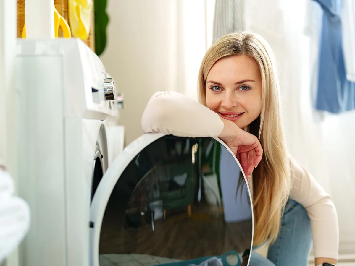 Femeie lângă mașina de spălat rufe - Foto: Freepik (Imagine cu rol ilustrativ)