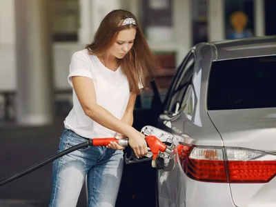 Femeie făcînd plinul la pompa de benzină - Foto: Freepik/prostooleh