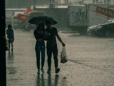 Tânăr cuplu mergând prin ploaie, sub umbrelă - Foto: Pexels/Nikita Korchagin