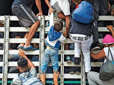 Migranţii venezueleni se caţără într-un camion, în Columbia, pe 10 februarie