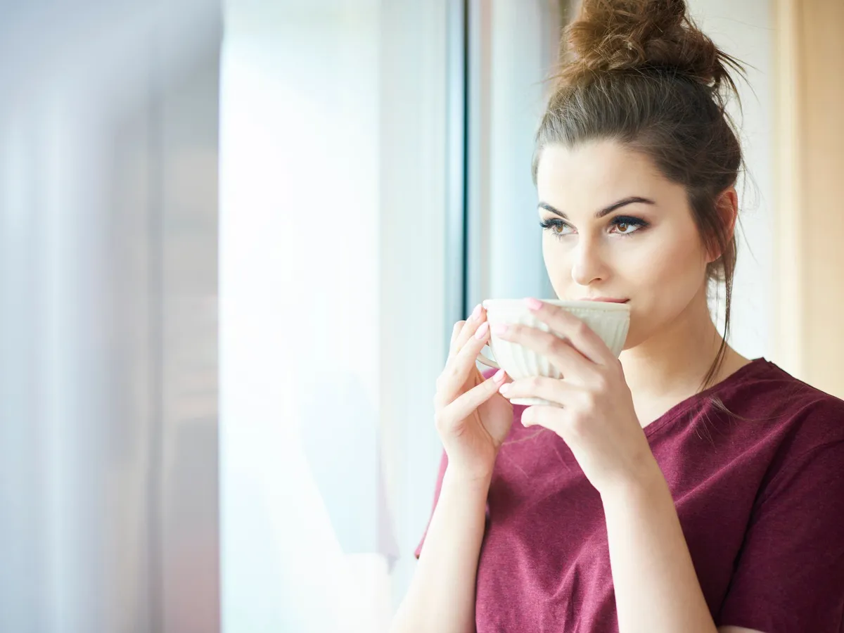 Femeie frumoasă care bea o ceașcă de cafea - Foto: Freepik