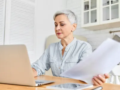 Pensionară făcând calcule - Foto: Freepik