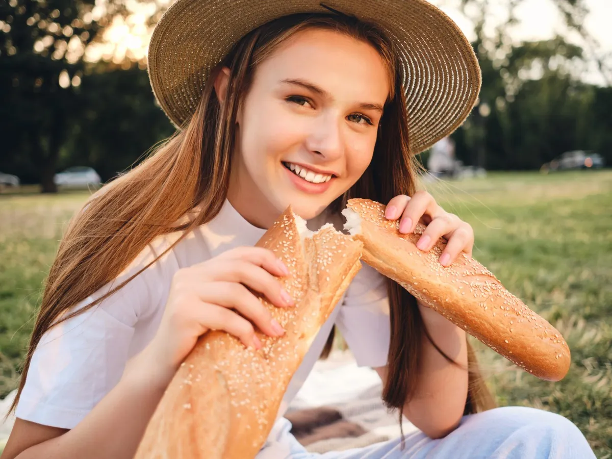 Tânără gustând pâine - Foto: Freepik
