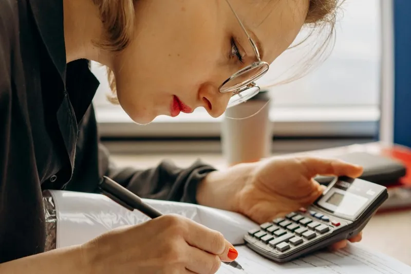 Femeie făcând calcule complicate - Foto: Pexels/Mikhail Nilov