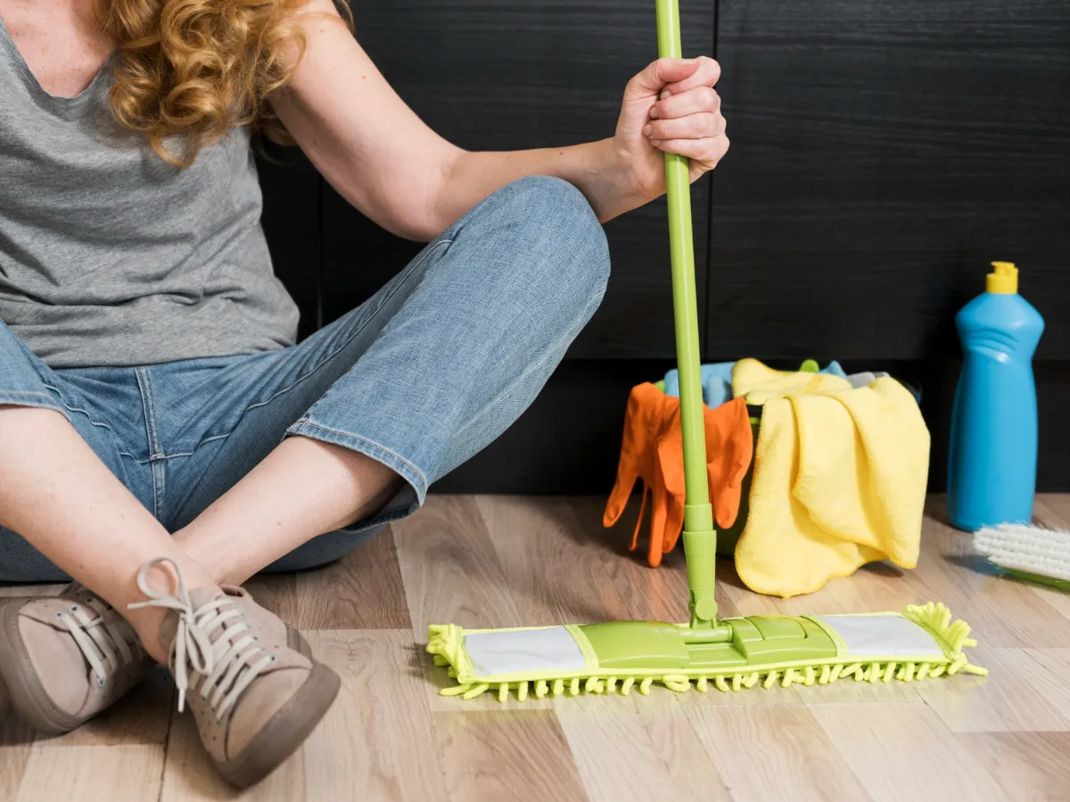 Femeie care ține un mop - Foto: Magnific.com (Imagine cu rol ilustrativ)