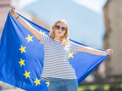 Femeiei cu steagul UE - Foto: Magnific.com (Imagine cu rol ilustrativ)