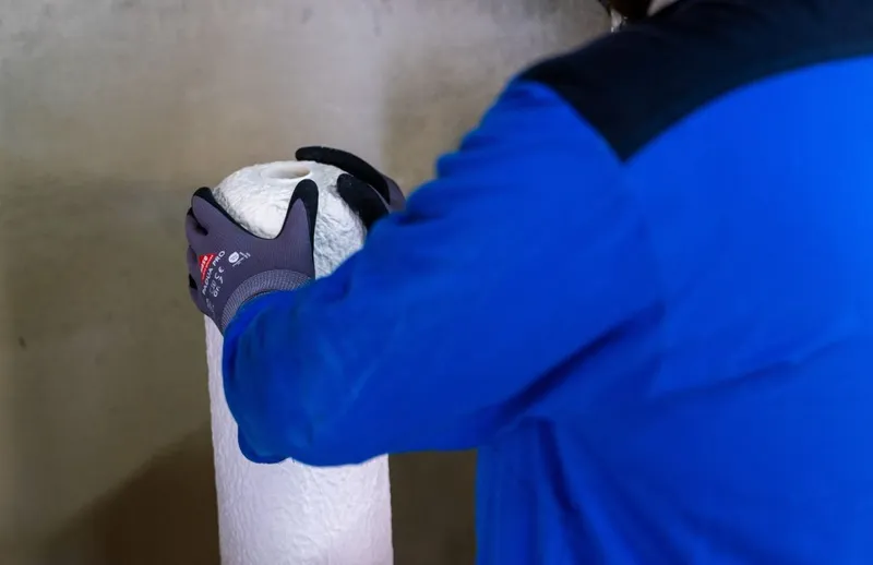 Un angajat Rheinmetall lucrează la o piesă brută, mată, combustibilă, turnată într-o mașină - Foto: Profimedia Images