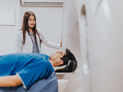 Tehniciană pregătind un pacient pentru imagistică medicală - Foto: Pexels/Charlss GonzHu