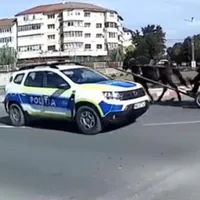 O căruță dă nas în nas cu mașina Poliției în giratoriu, pe cotrasens, în mijlocul orașului. / Foto: captură video