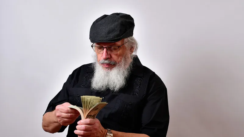Un pensionar își numără pensia specială - Foto: Freepik