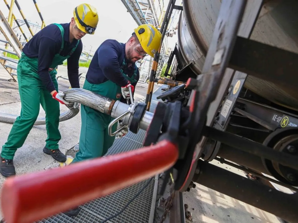 Muncitorii primesc aditiv lichid pentru rafinarea petrolului, dintr-un tren cisternă, la Rafinăria Duna a MOL - Foto: Profimedia Images