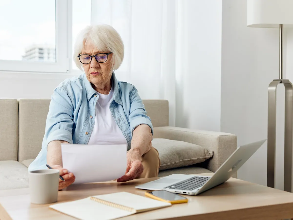 Pensionară făcând calcule - Foto: Freepik