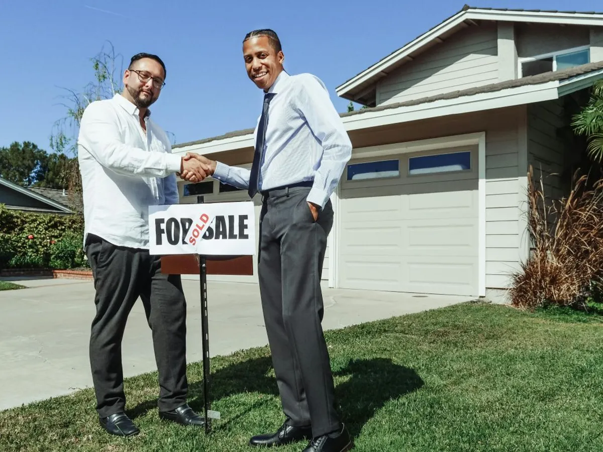 Doi bărbaţi îşi strâng mâna, în privinţa unei afaceri imobiliare - Foto: Pexels/Kindel Media