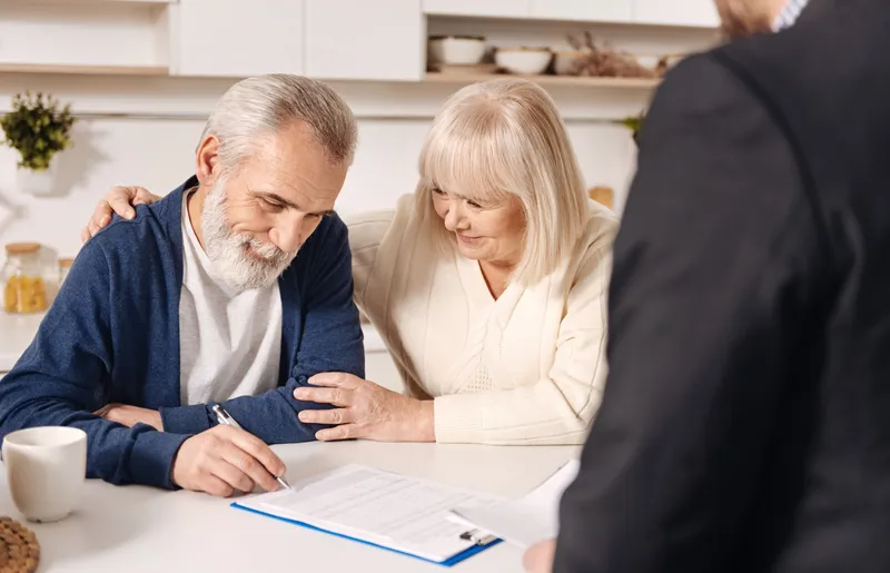 Pensionari la pensie semnează acte - Foto: Freepik