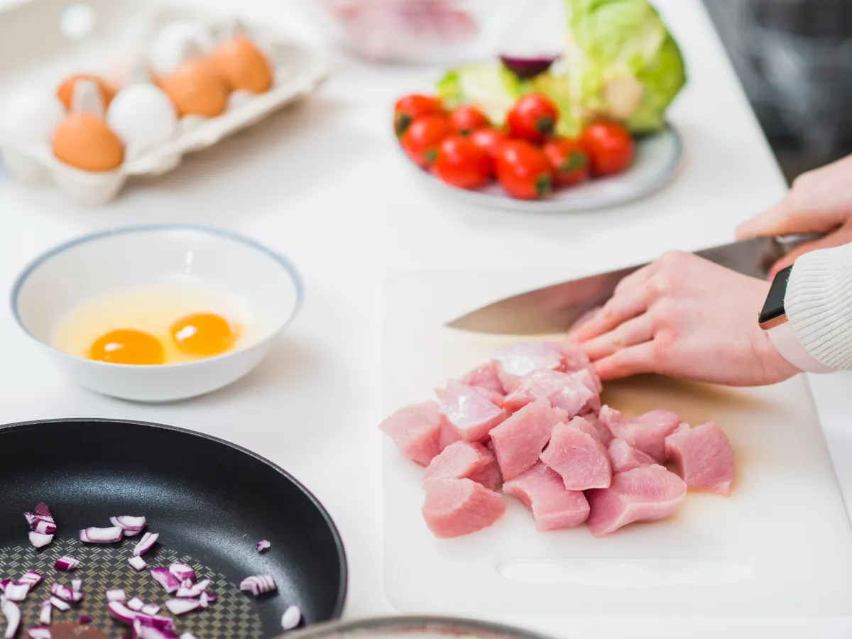 Masă de gătit cu mâinile tăind carne - Foto: Freepik (Imagine cu rol ilustrativ)