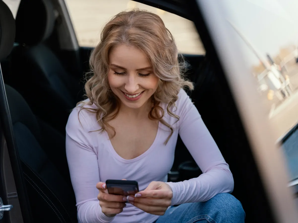 Femeie care stă pe telefon în mașină - Foto: Magnific.com (Imagine cu rol ilustrativ)