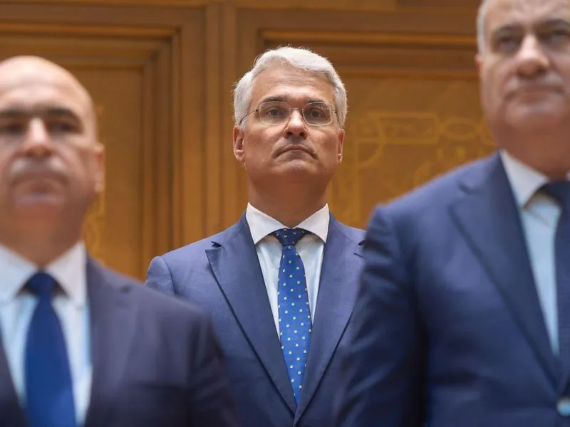Ministrul desemnat al fondurilor europene, Dragoş Pîslaru, aşteptând votul Parlamentului, între premierul Bolojan şi vicepremierul Neacşu - Foto: Profimedia Images