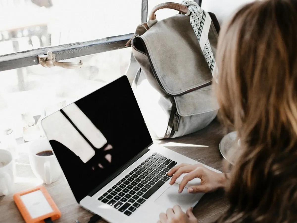 Femeie stând la birou, folosind laptopul - Foto: Pexels/Andrew Neel