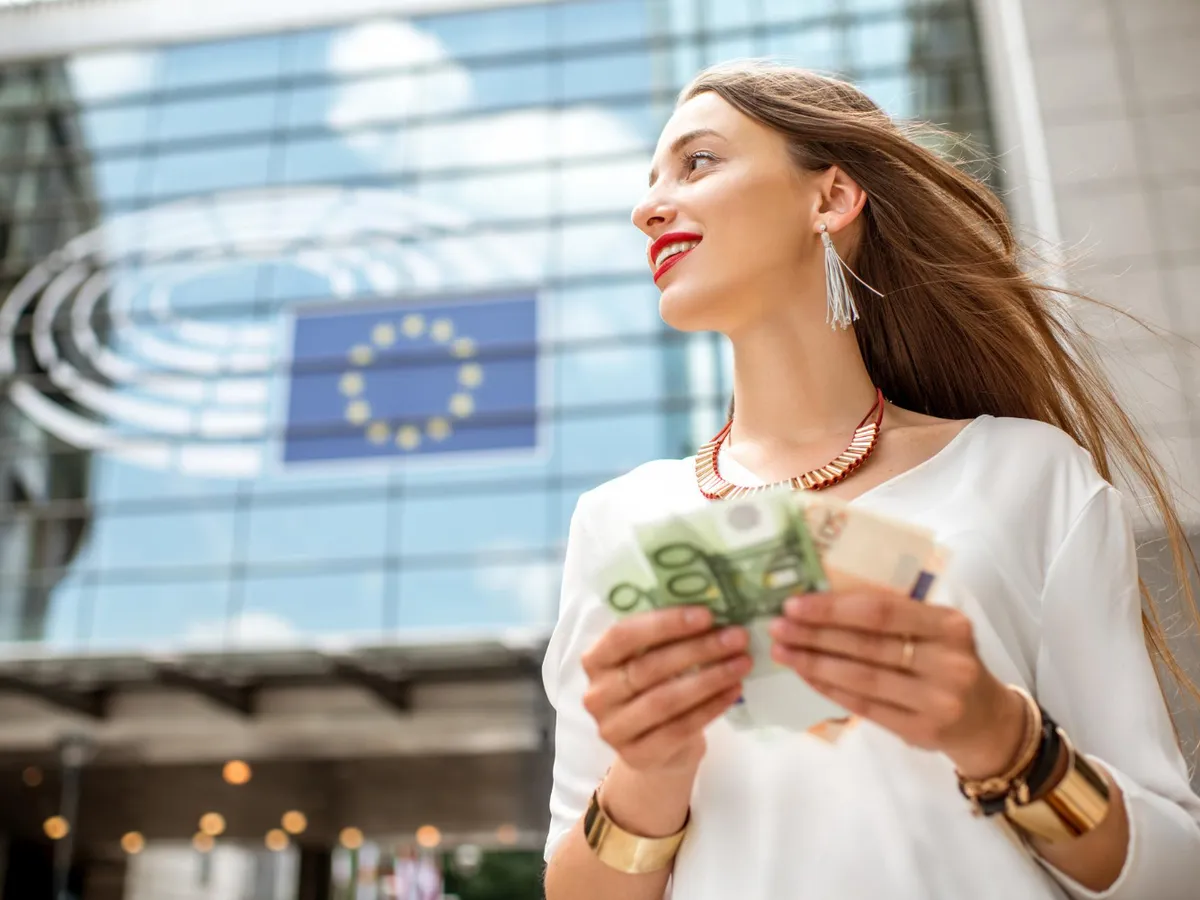 Femeie cu euro în mână - Foto: Magnific.com (Imagine cu rol ilustrativ)