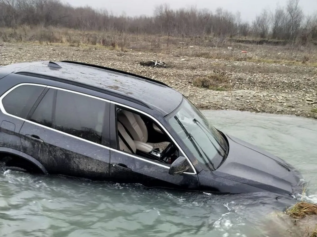 Un șofer a fugit de poliție cu un SUV BMW și a sărit cu mașina într-un râu, rămânând împotmolit - Foto: IPJ Neamț