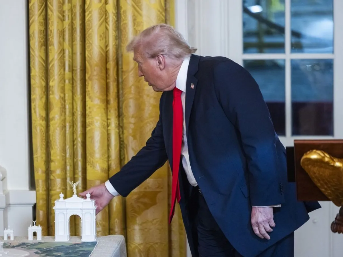 Donald Trump atinge o machetă a Arcului de Triumf pe care vrea să-l construiască - Foto: Profimedia Images