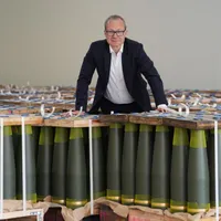 Matthias Koll, director financiar al Rheinmetall Weapon and Ammunition, stă între proiectile de artilerie de calibru 155 mm - Foto: Profimedia Images