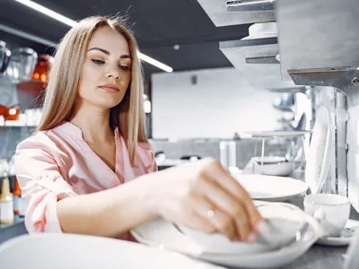 Femeie la mașină de spălat vase - Foto: Freepik