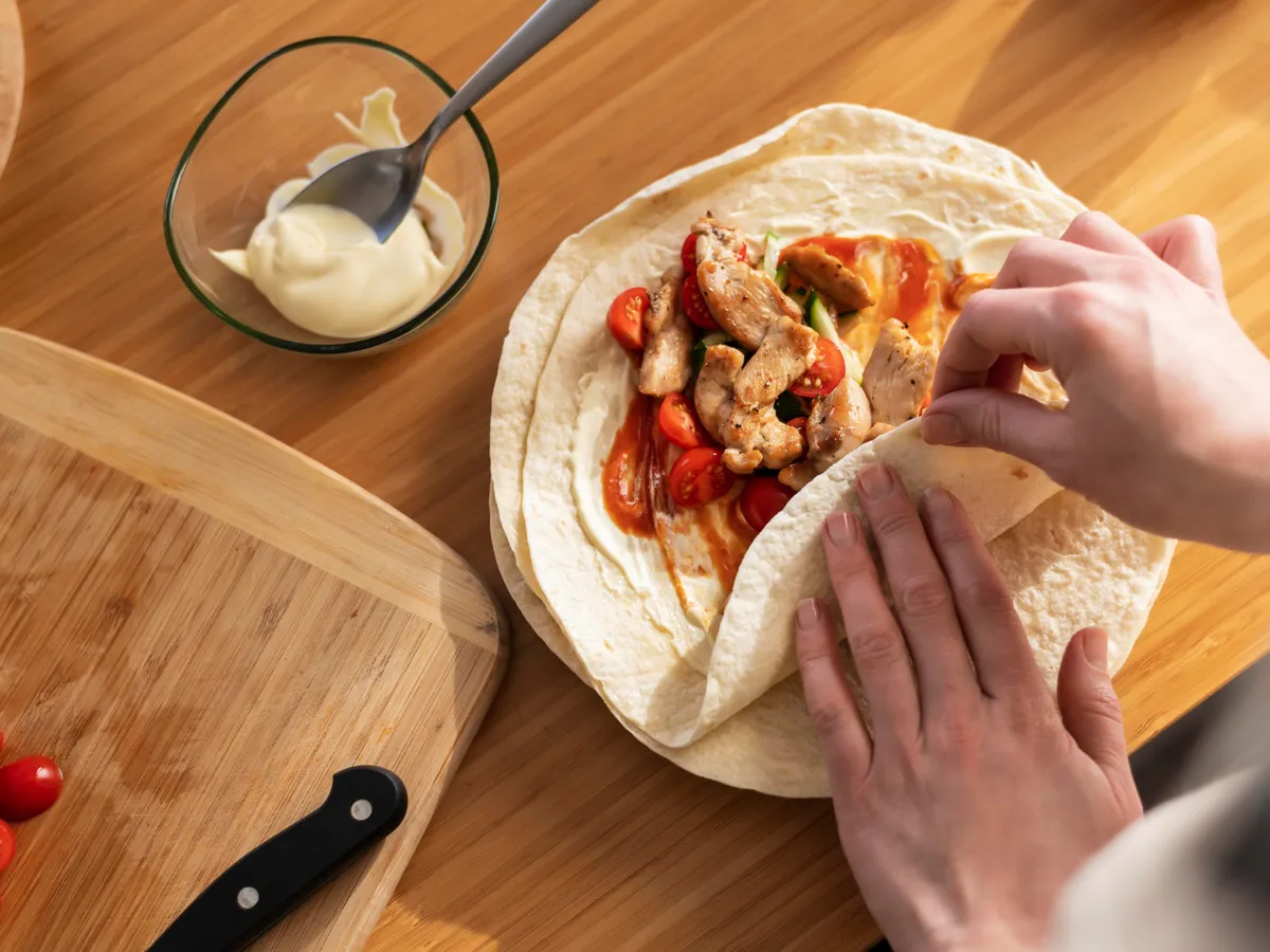 Persoană care împachetează shaorma - Foto: Freepik (Imagine cu rol ilustrativ)