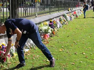 Un localnic din Christchurch depune flori în fața unui memorial amplasat în oraș