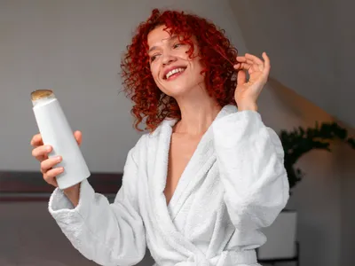 Femeie cu un șampon în mână - Foto: Magnific.com (Imagine cu rol ilustrativ)