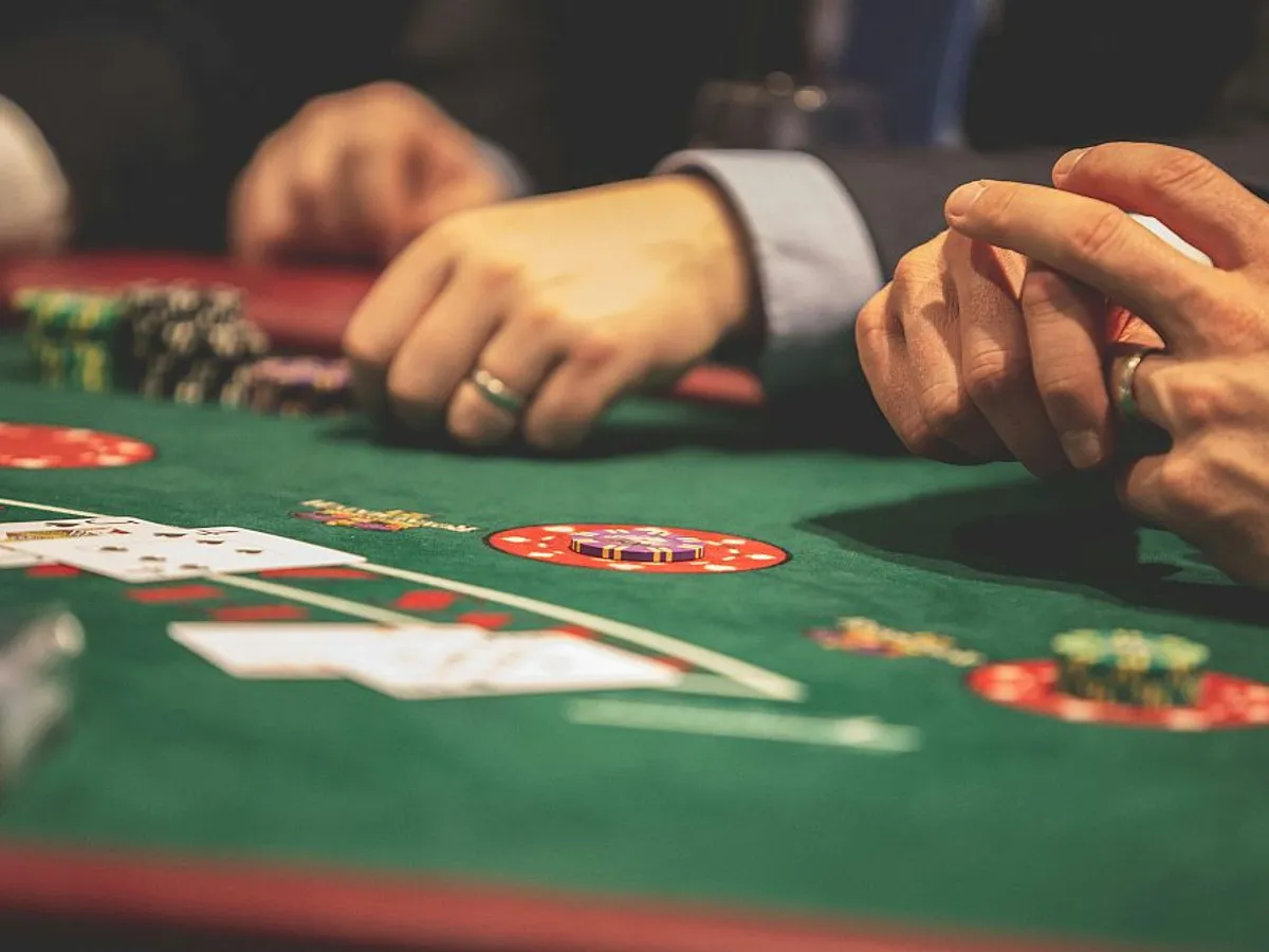 Mâini ale jucătorilor, la masa de joc, într-un cazinou - Foto: Pexels/Drew Rae