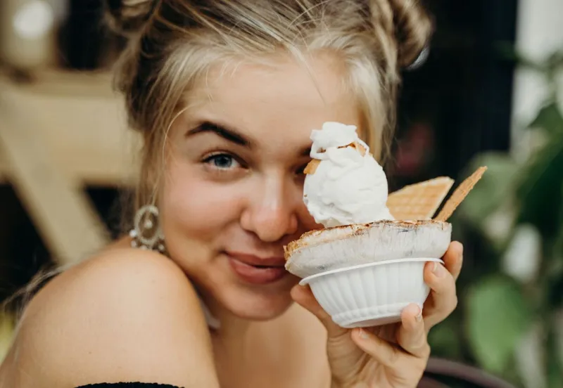 Femeie bucur&acirc;ndu-se de o &icirc;ngheţată la pahar - Foto: Pexels/Alesia Kozik
