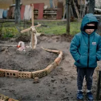 Imagine-simbol a crimelor lui Putin în Ucraina: Un copil de 6 ani așteptă lângă mormântul mamei sale / twitter