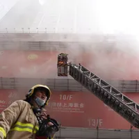 Pompierii încearcă să evazueze oamenii din turn. FOTO: South China Post